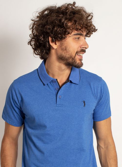 Camisa polo azul combina com short estampado em cores neutras ou com estampa predominantemente no mesmo tom